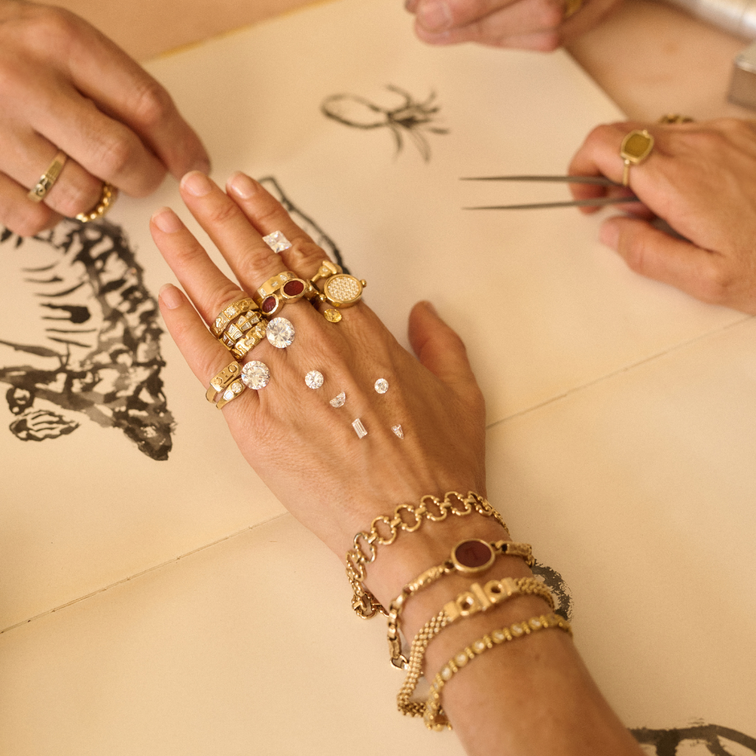 Close-up of hands wearing Lucy Folk gold jewellery in the bespoke studio.